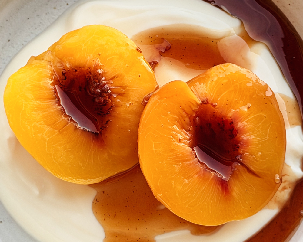 Close up of two Honey poached peaches on a bed of Greek yoghurt 