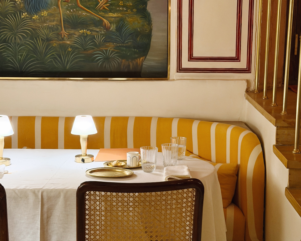  A tucked-away table beside a striped yellow banquette at The Johri Restaurant, Jaipur. 