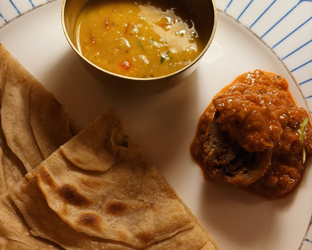  Toor Dal Tarka, red curry and naan on a white plate at The Johri Restaurant, Jaipur. 