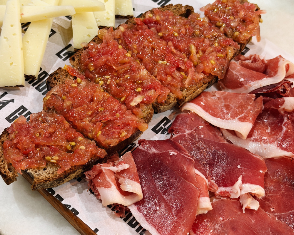  Pan con tomate served alongside slices of jamón and cheese at La Colmada. 