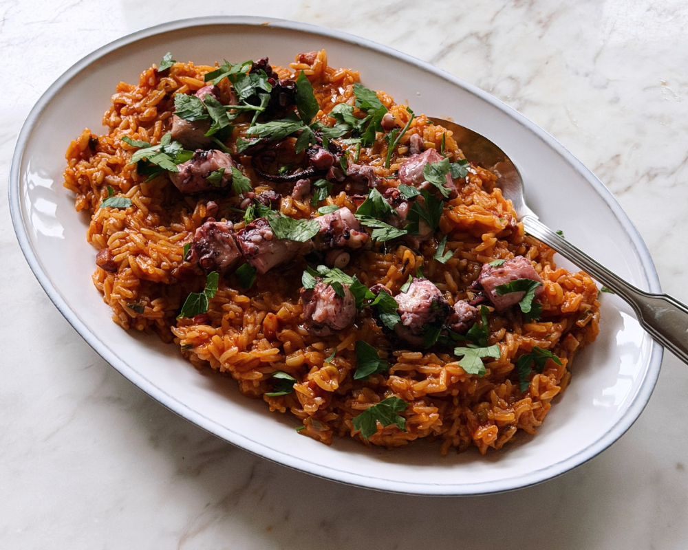  Portuguese octopus rice topped with fresh parsley on a white plate 
