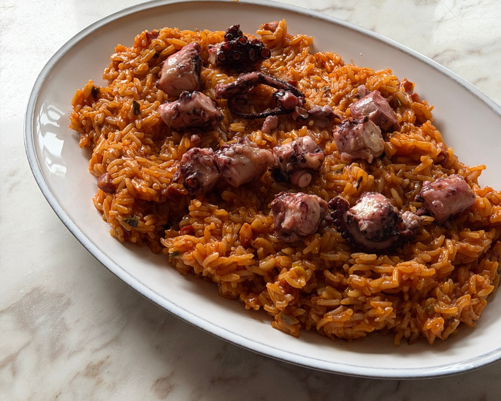  One pot Portuguese octopus rice served on a white oval plate 