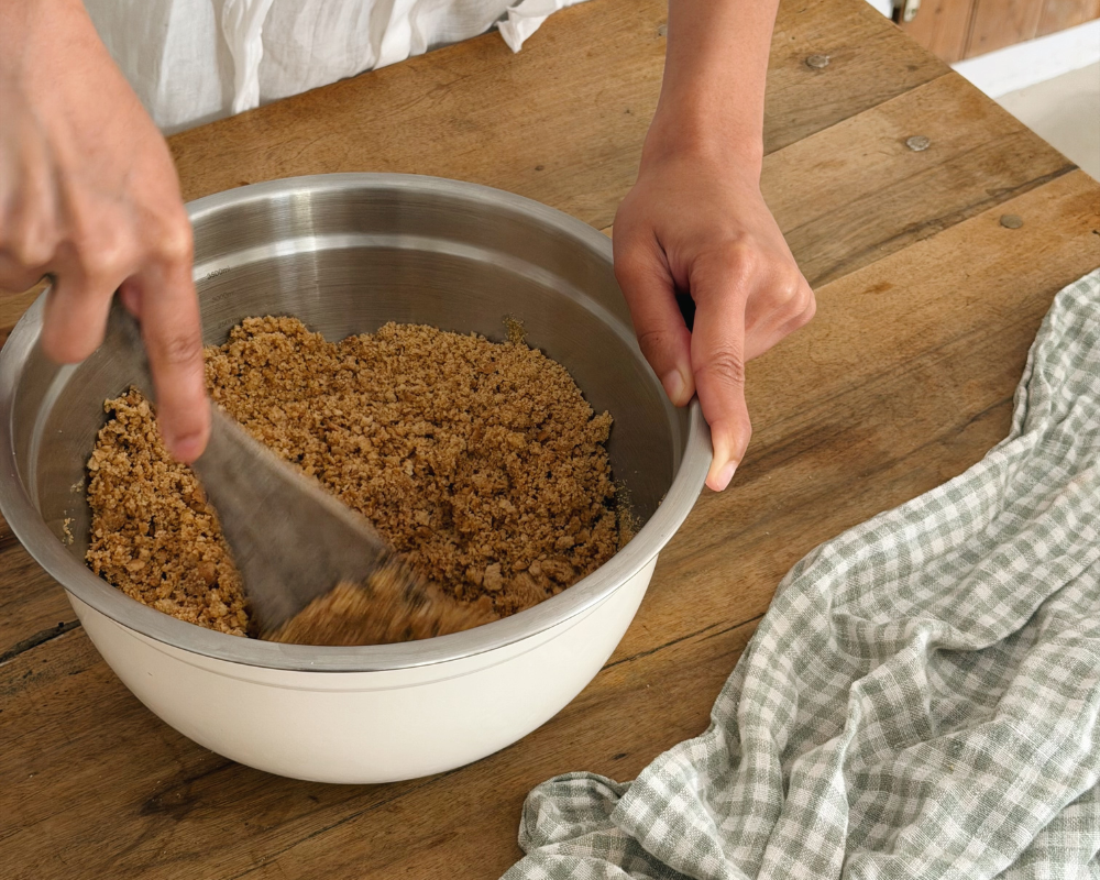  Mixing crushed biscuits with melted butter for a no-bake apricot and ricotta tart base 