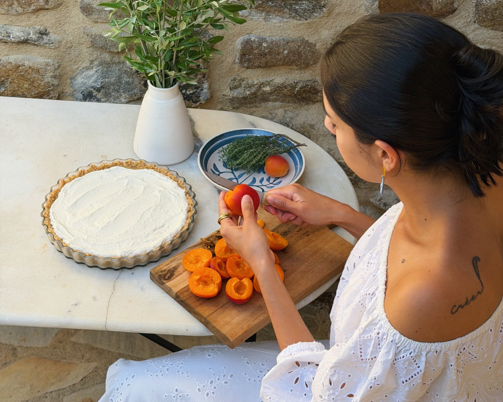  Halving fresh apricots on a wooden board to top a no-bake ricotta tart 