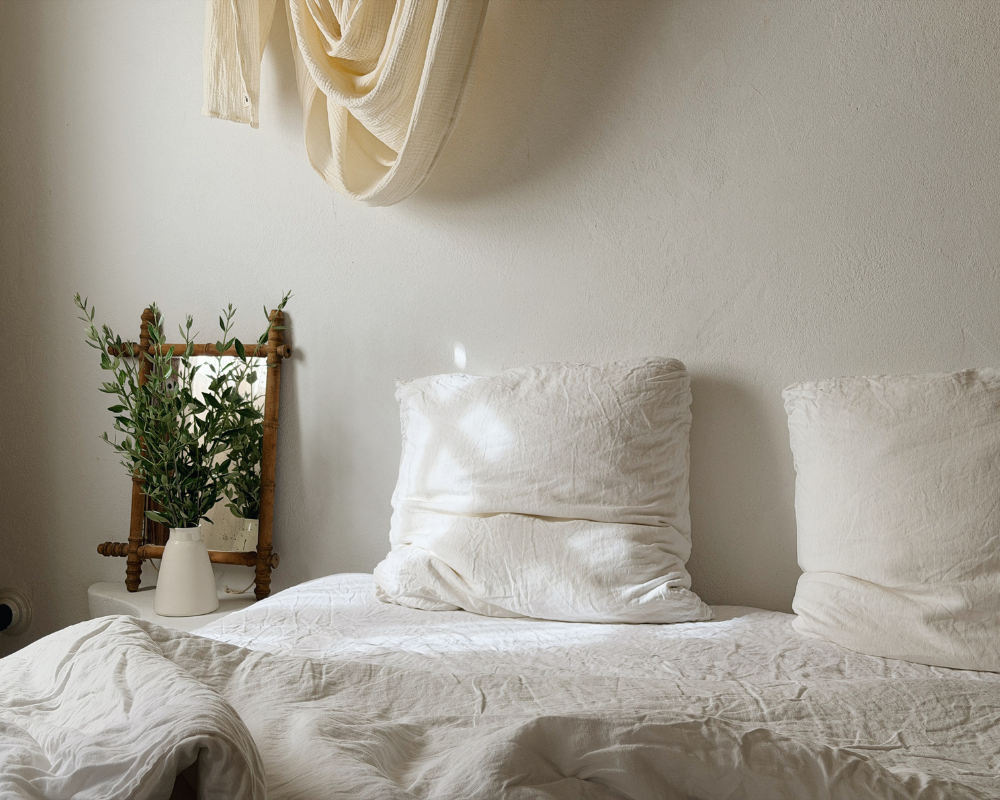  White linen bedding and pillows in a sunlit bedroom at Maison Santcha 