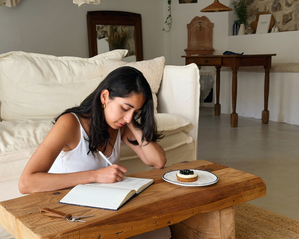  Better With Spice writing in a journal beside a slice of tart at Maison Santcha 