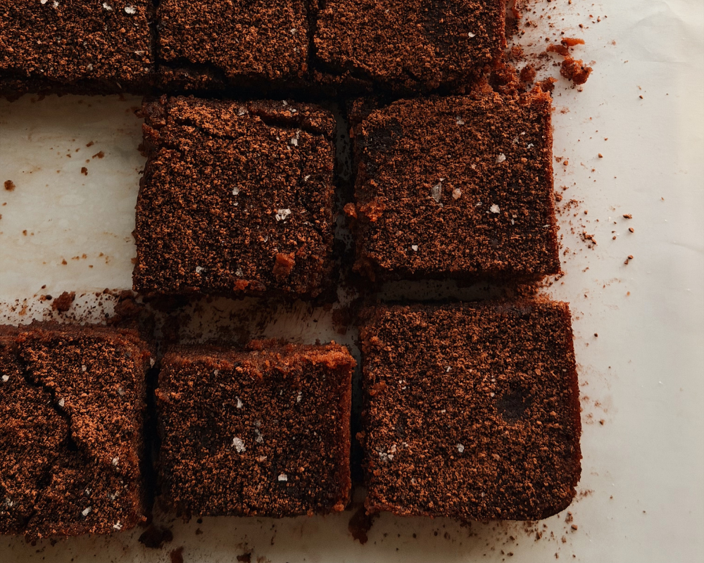  Fudgy hazelnut brownie squares on white baking paper 