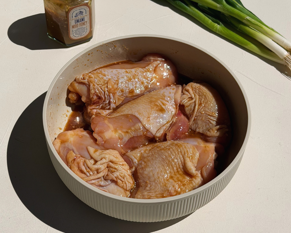  Marinated chicken in a bowl for sticky Miso Honey Chicken. 