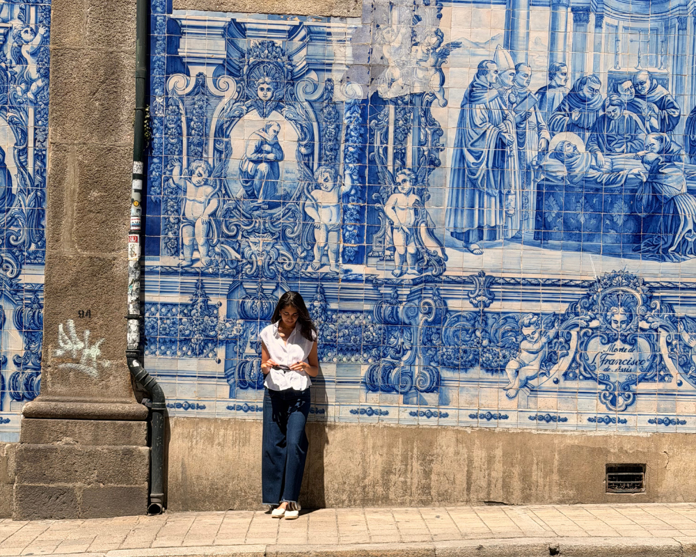  Woman standing in front of a blue and white azulejo tiled wall in Porto 