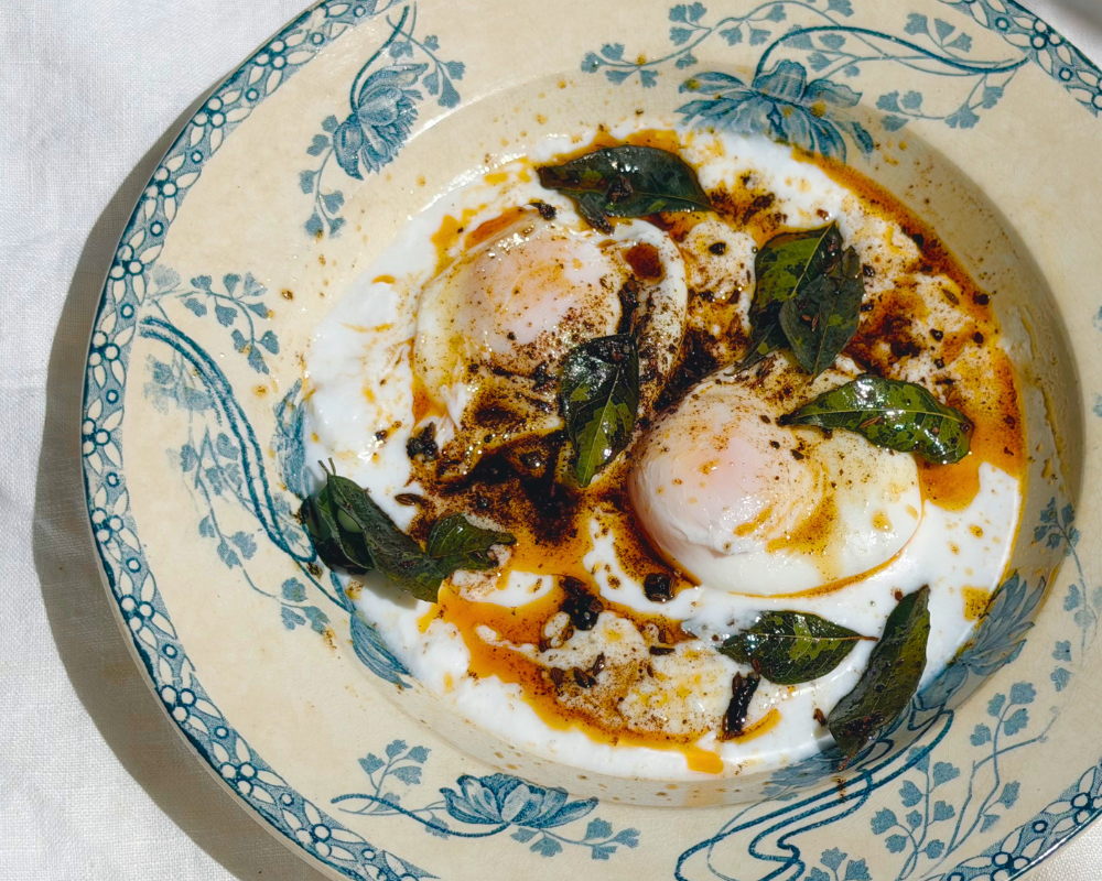  A blue and white stew bowl with poached eggs on yoghurt with tempered spices for Indian-ish Turkish Eggs 