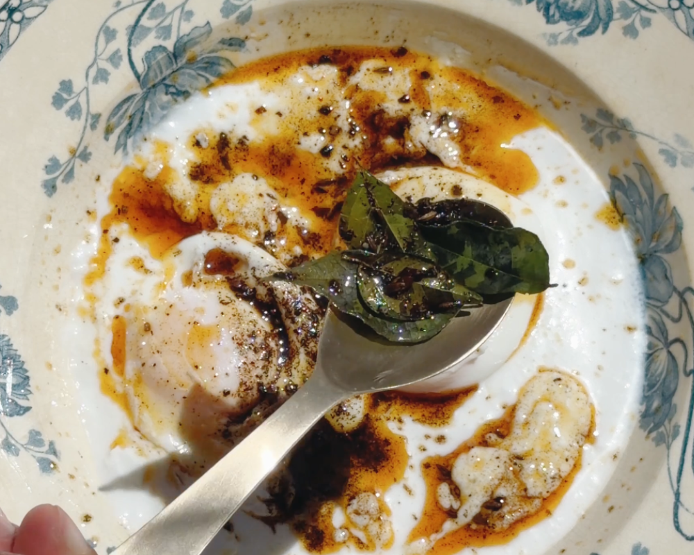  Tempered curry leaves being spooned over Indian-ish Turkish Eggs 