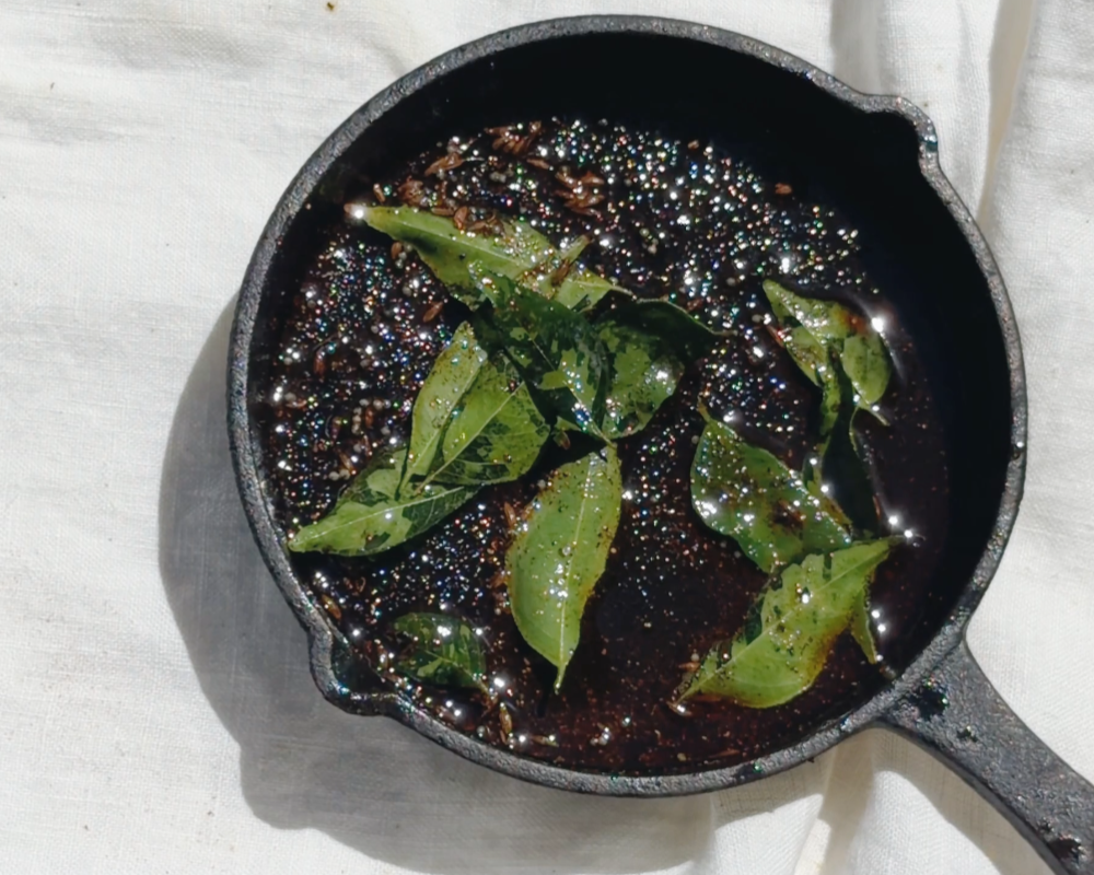  Curry leaves and spices tempering in a black cast iron pan for Indian-ish Turkish Eggs 