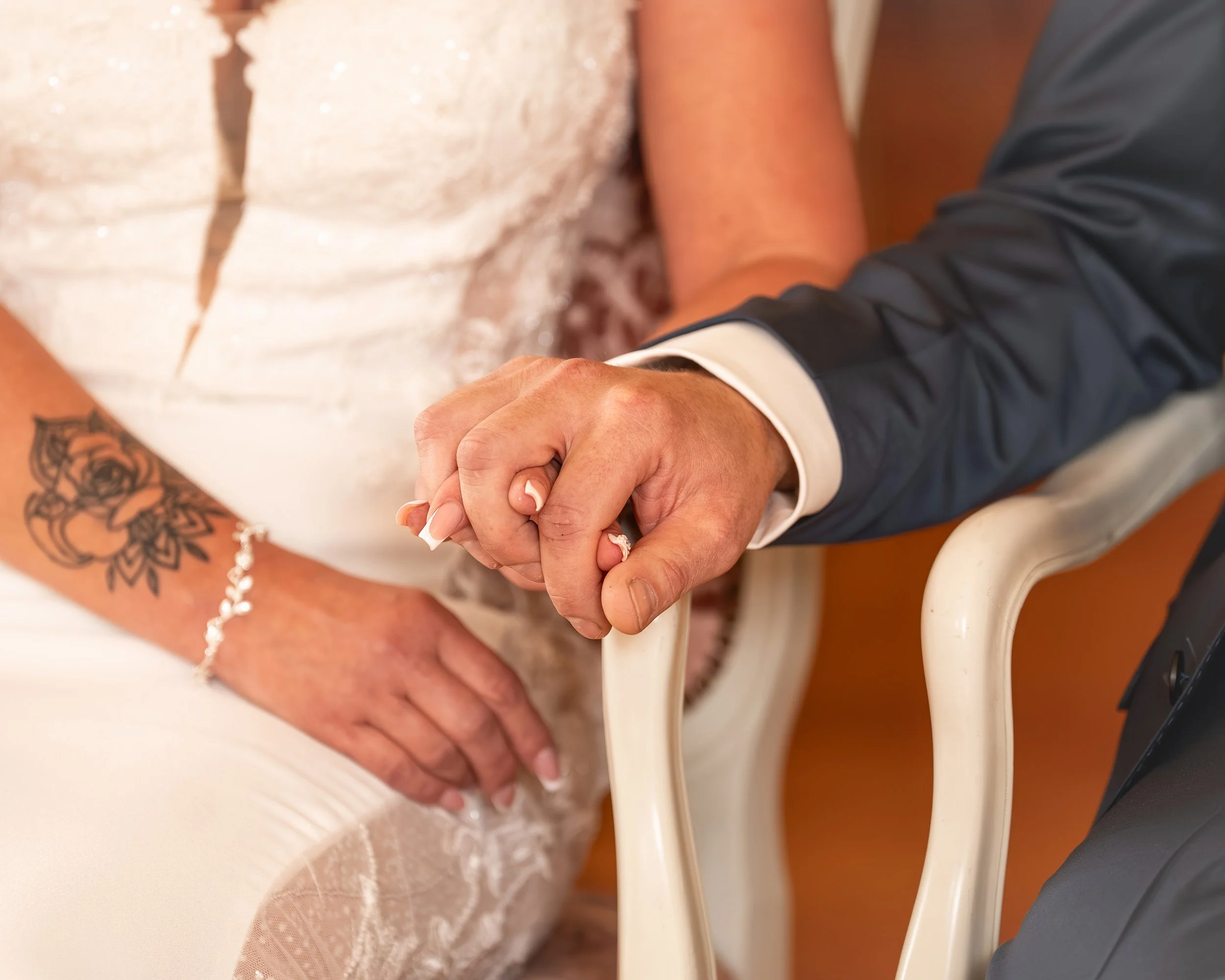 Ein Hand hält die Hand einer anderen Person während einer offiziellen Zeremonie, vermutlich bei einer Eheschließung.