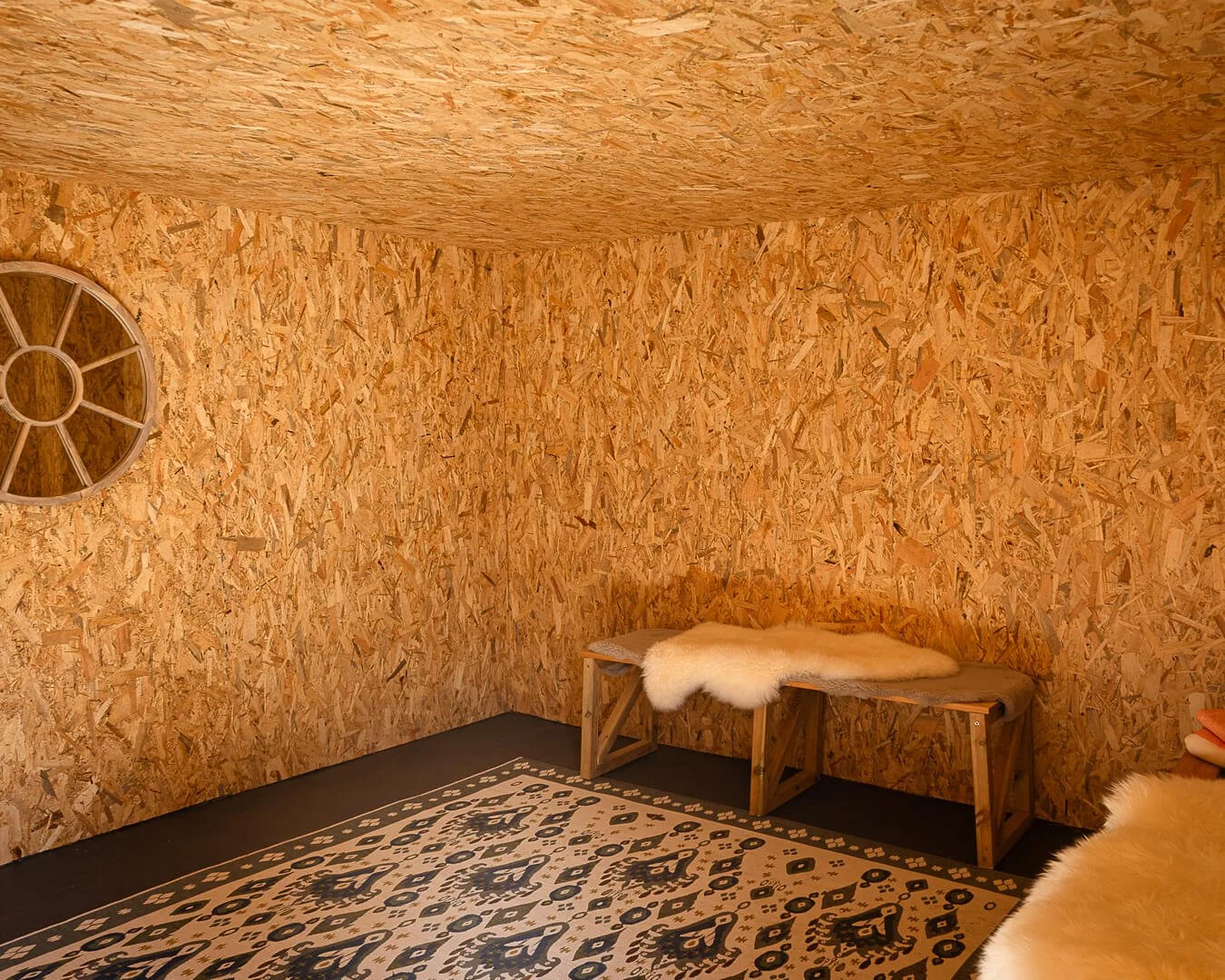 Wooden-changing-room-at-Melancoose-with-round-mirror-on-wall-and-benches-with-sheepskin-rugs.jpg
