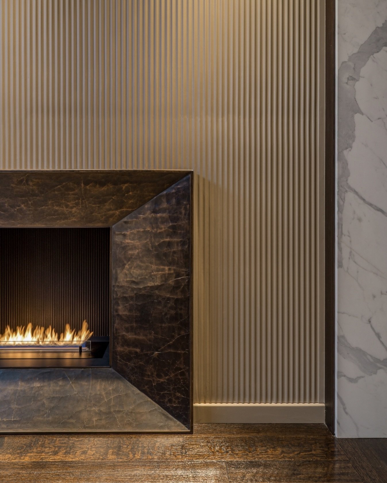Where materials define the mood...⁠
⁠
In this scheme, the meeting of a modern metal fireplace surround, fibrous wall panelling, stone doorway frames, and heritage timber flooring creates a layered composition of texture and tone. Each material brings