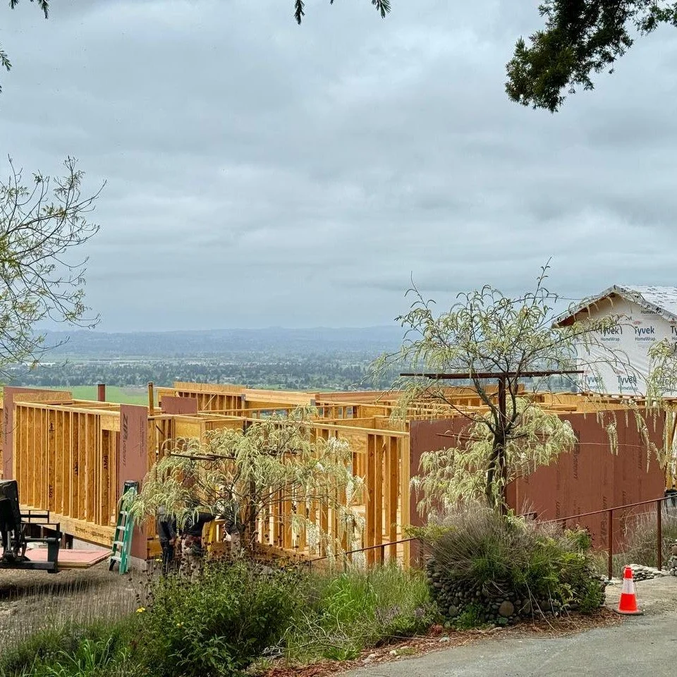 A construction site showing wood framing, a vista of the Santa Rosa flats beyond.