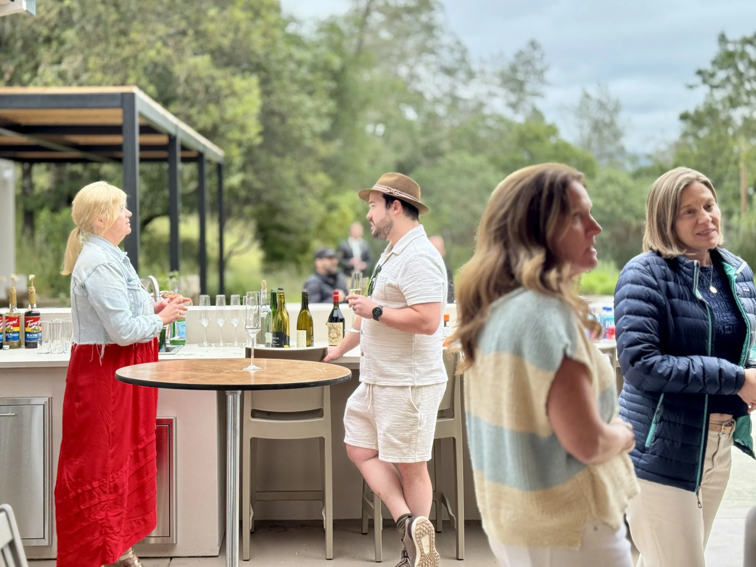 People standing around at a party, drinks in hand.