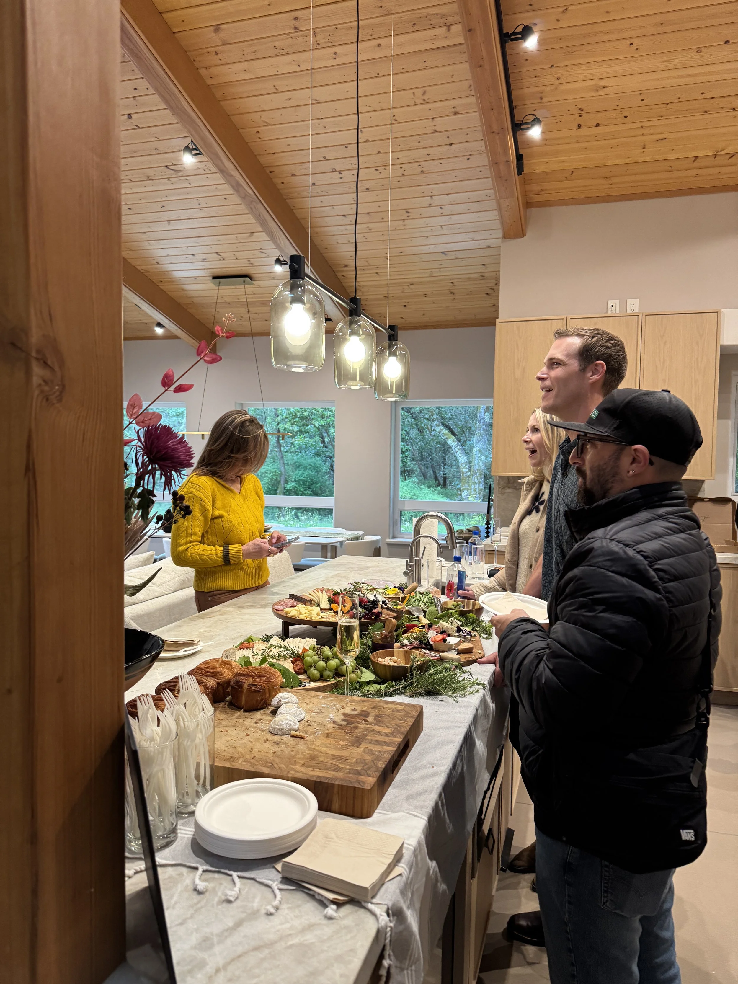 Candid conversation between party goers in front of a buffet of food