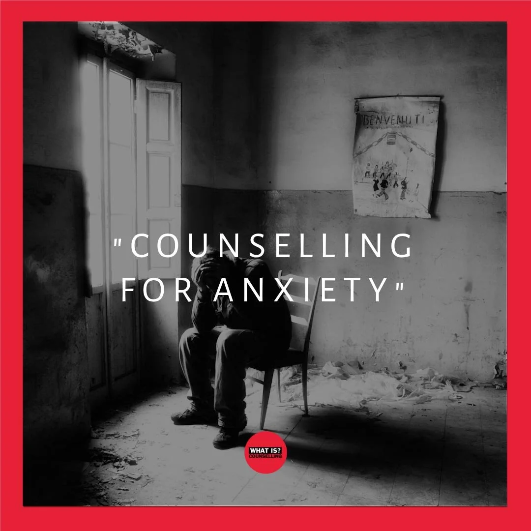 An image of a person sat alone on a chair in dark and dirty room with their head in their hands looking down