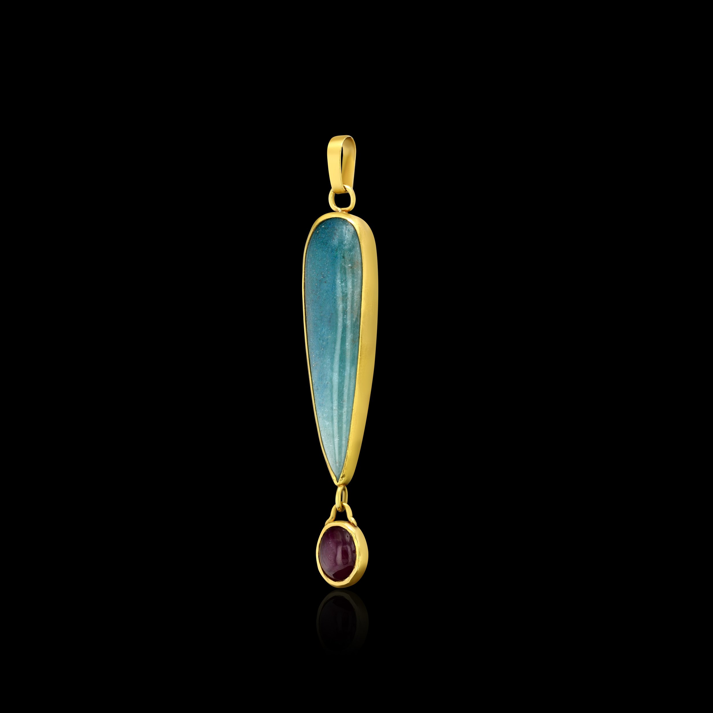 side view of a pendant with a long, blue quartz and oval ruby cabochons set in 22k gold