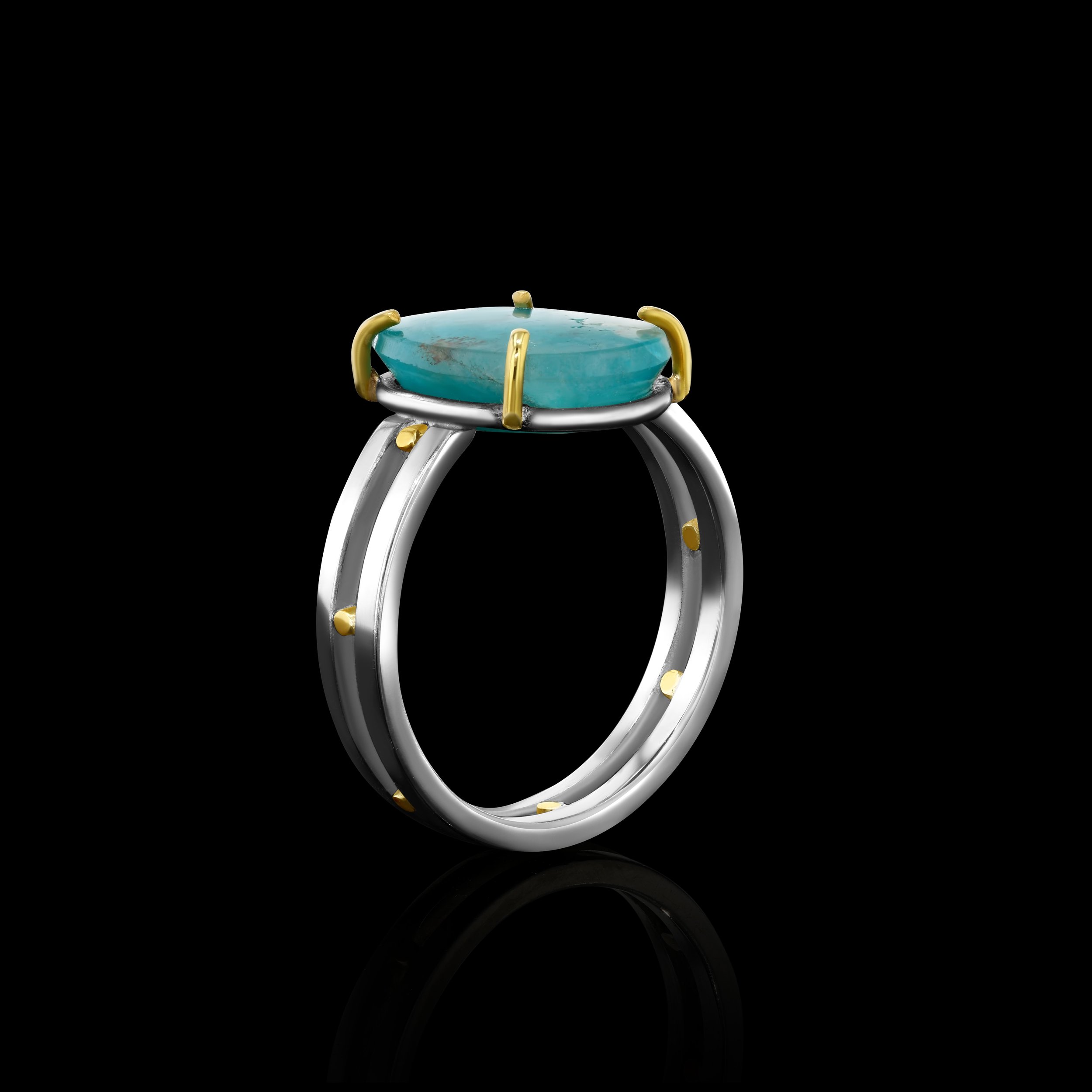 side view of a silver and gold ring with a bright blue stone