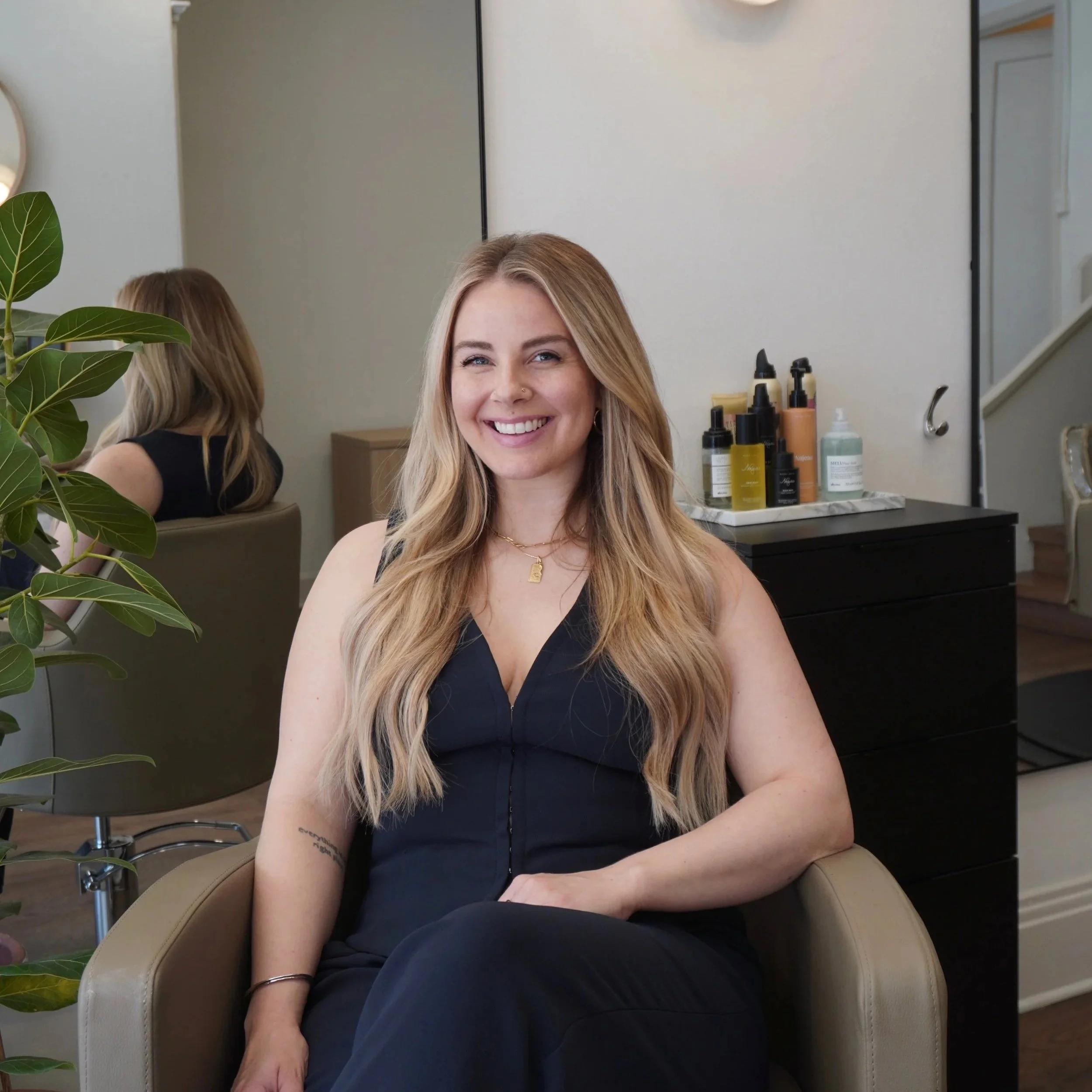 Woman smiling with hair salon in background