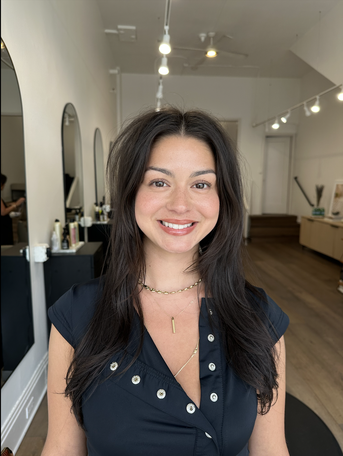 Woman smiling with hair salon in background