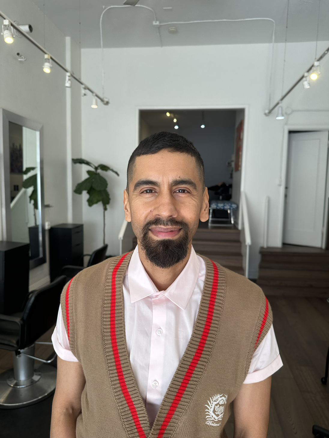 Man smiling with hair salon in background