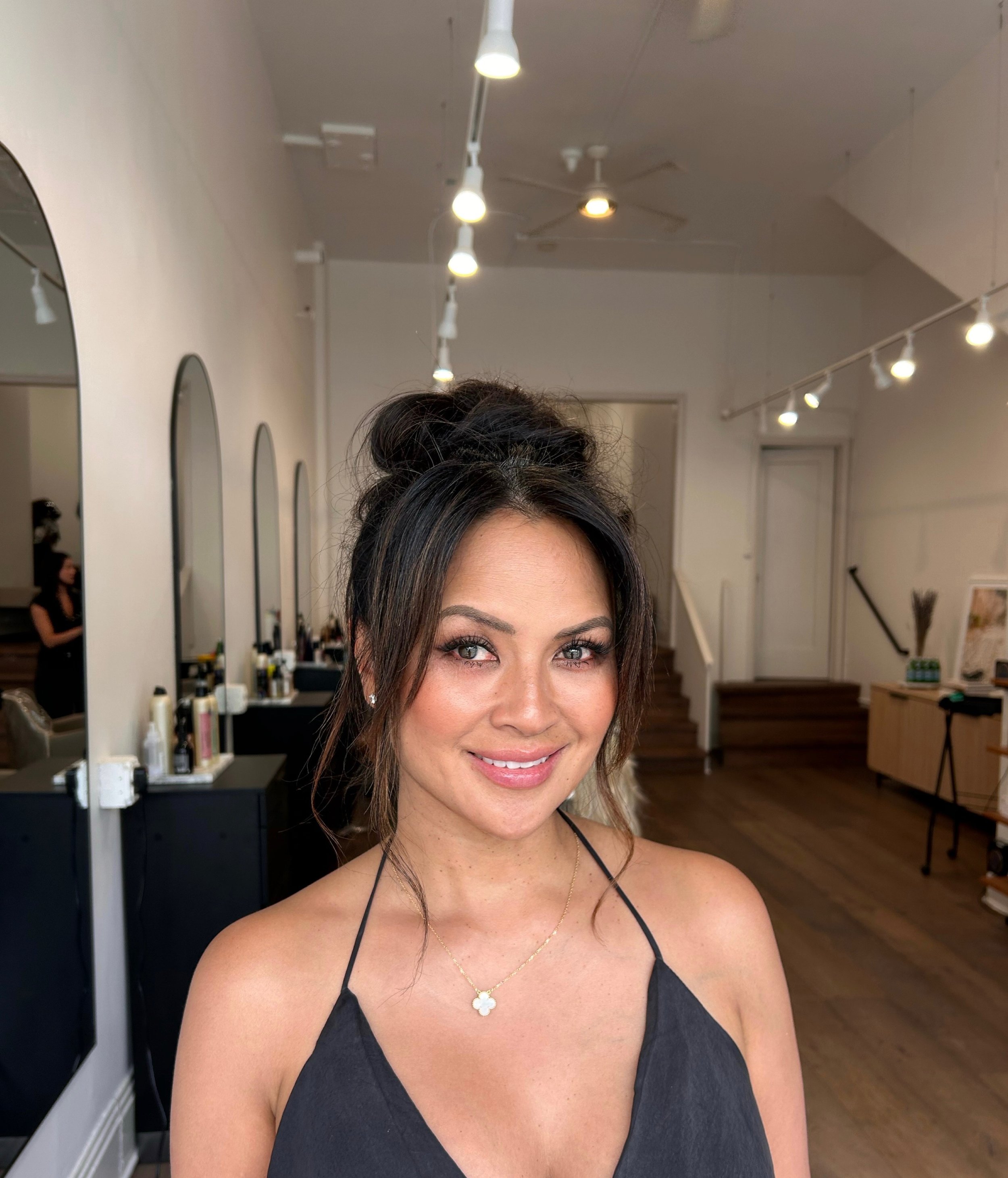 Woman smiling with hair salon in background