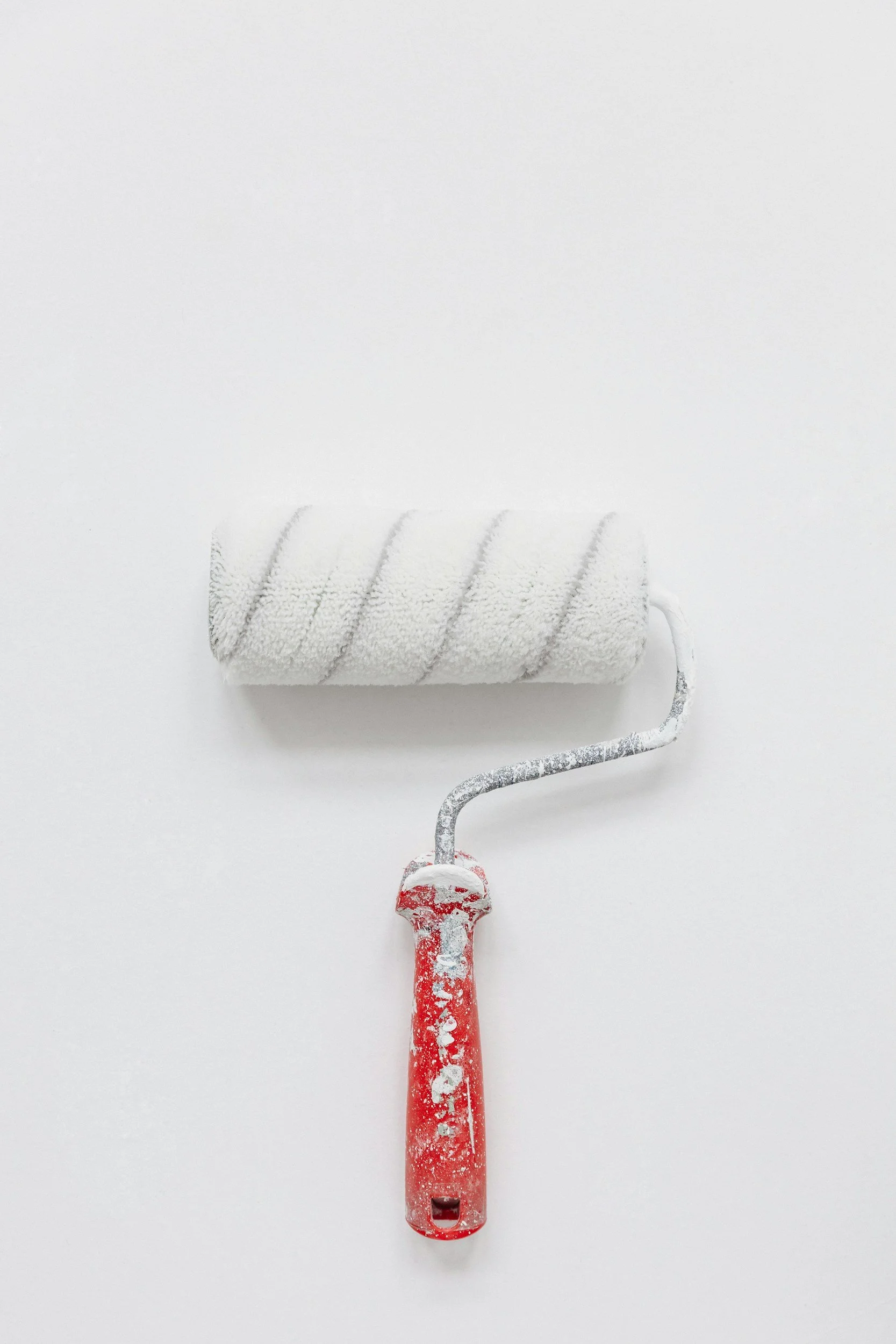 Paint roller with a red handle on a white background.