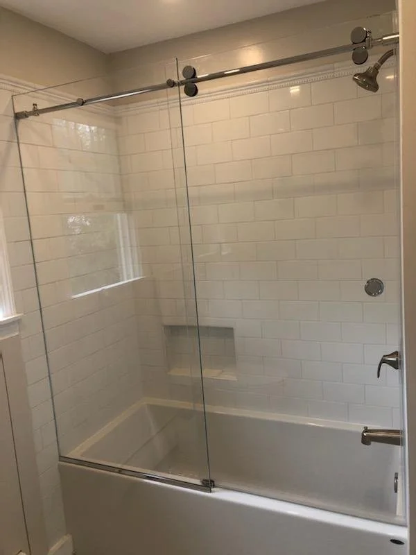 Modern bathroom with glass shower enclosure and white subway tiles