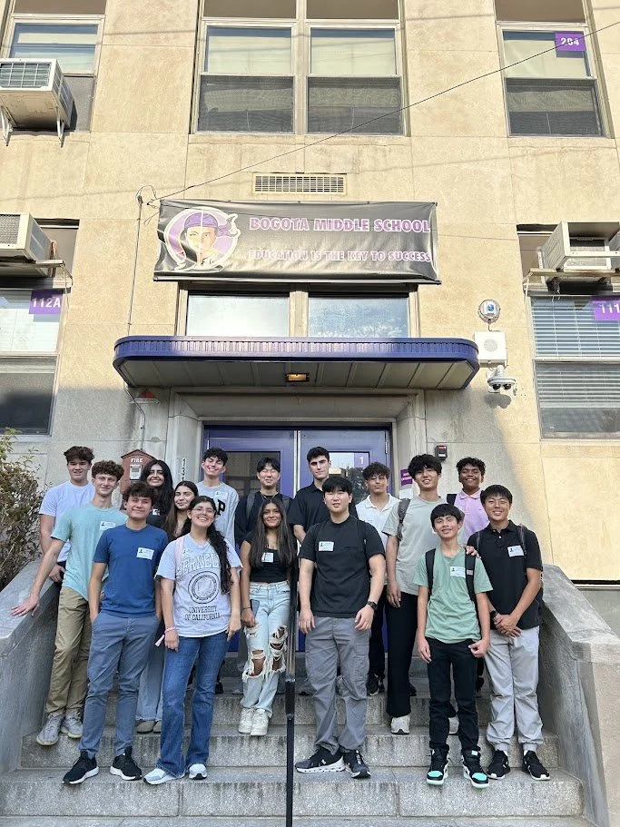 Group of middle school students standing on the steps in front of Bogota Middle School building.