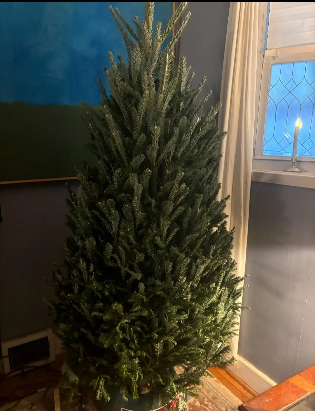 A house with a blue front door and white siding, with a ladder leaning against it, and a yellow cherry picker lift with an extended arm in the driveway.