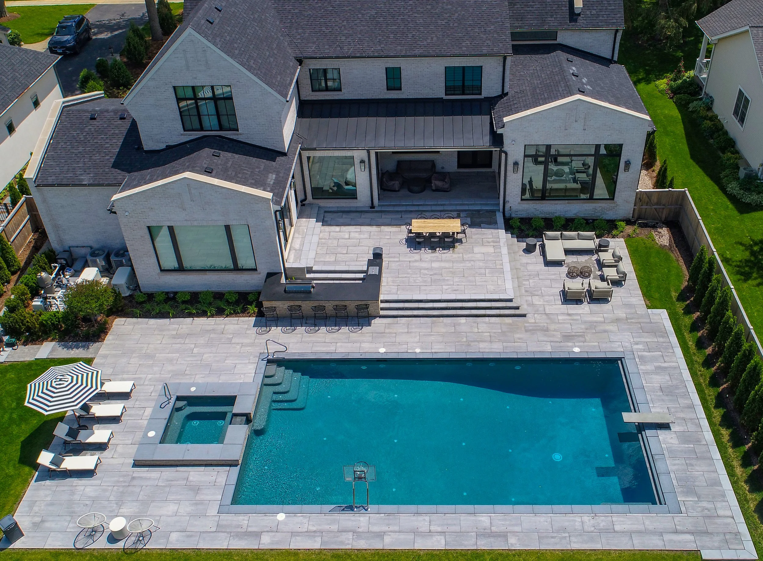 Luxury backyard pool built by Barrington Pools in Elmhurst water features, diving board, pebbletec pool finish