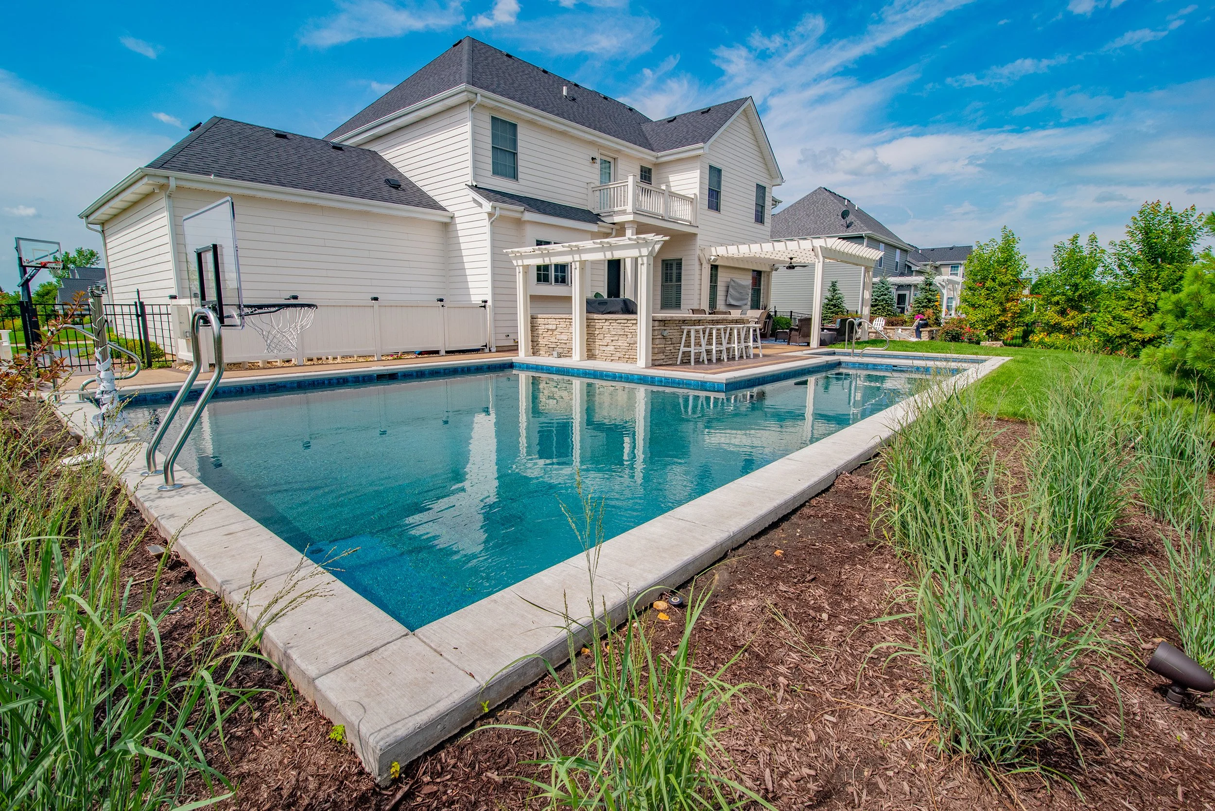Barrington Pools built geometric pool with outdoor kitchen and bar