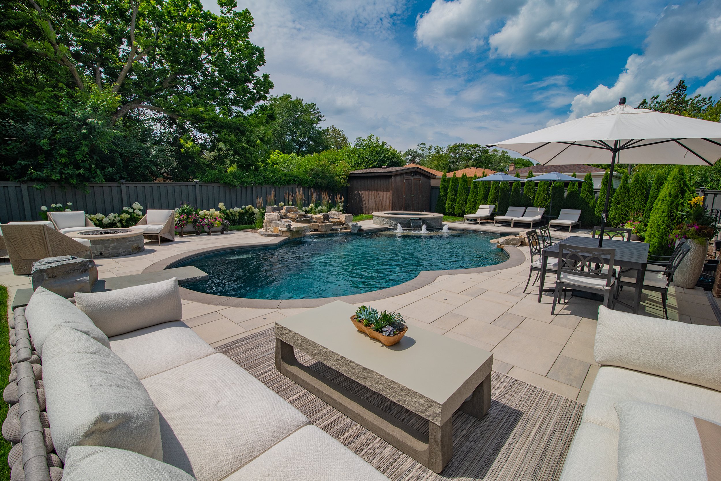 Luxury backyard pool with water feature, spa and outdoor living areas