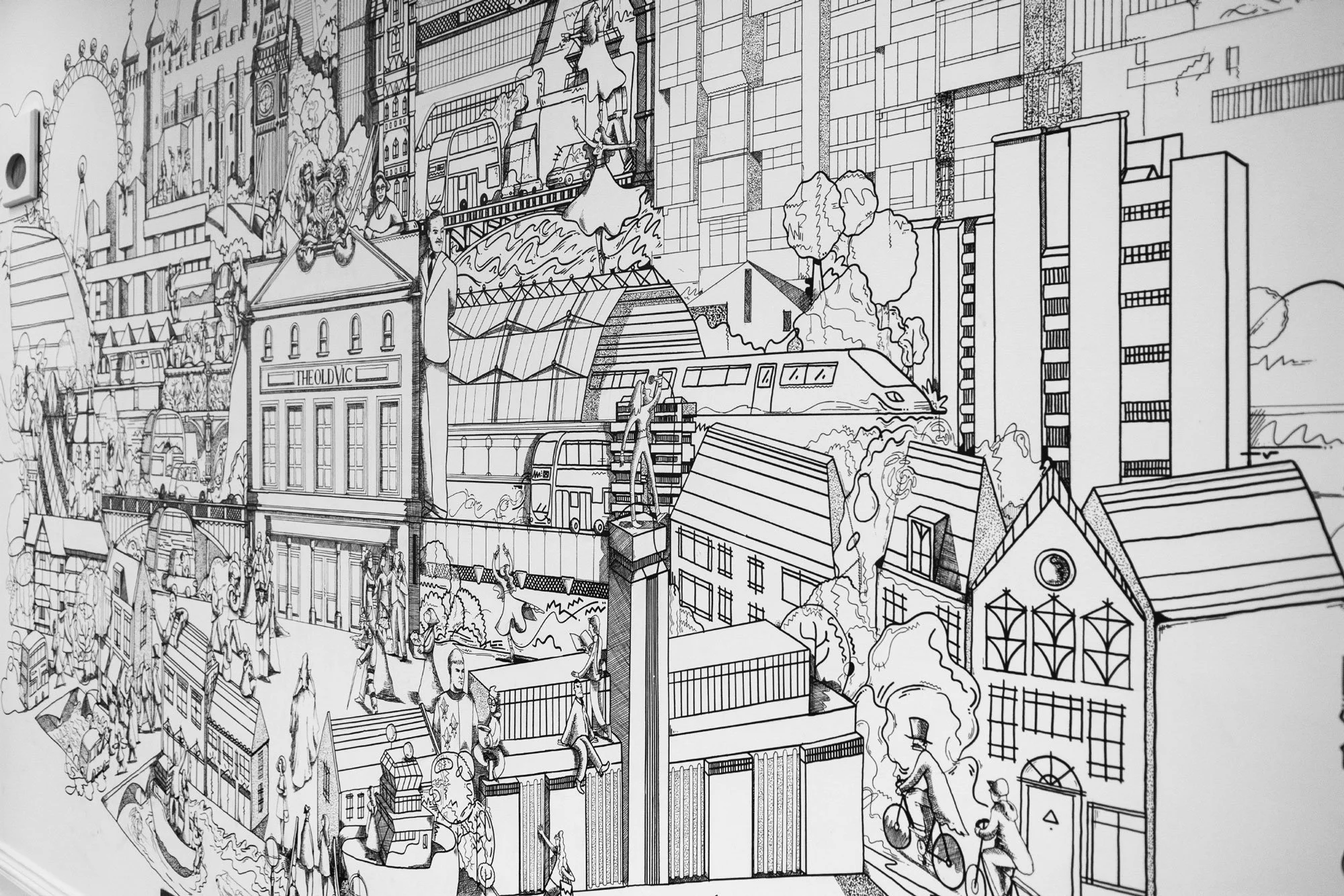Side view of hand-painted mural installation by Chris Martin illustrator – large-scale black ink drawing featuring The Old Vic Theatre building, Battersea Power Station, London train and architectural cityscape detail, The Old Vic Theatre London