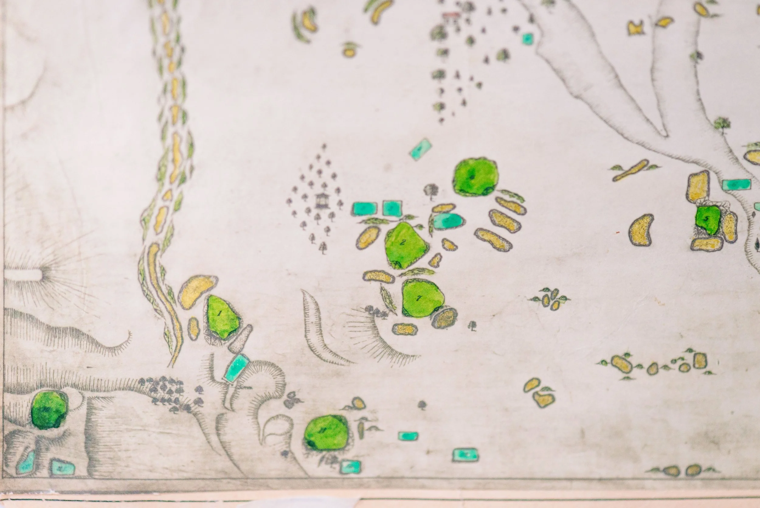 A detailed hand-drawn map showing various land features, structures, and natural landmarks with different colors and symbols.