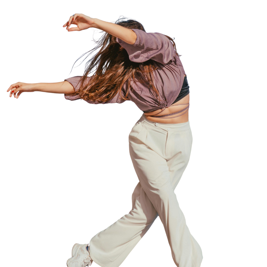 Person dancing, wearing a loose purple shirt, black top, beige pants, and sneakers, with long wavy hair, mid-motion against a white background.