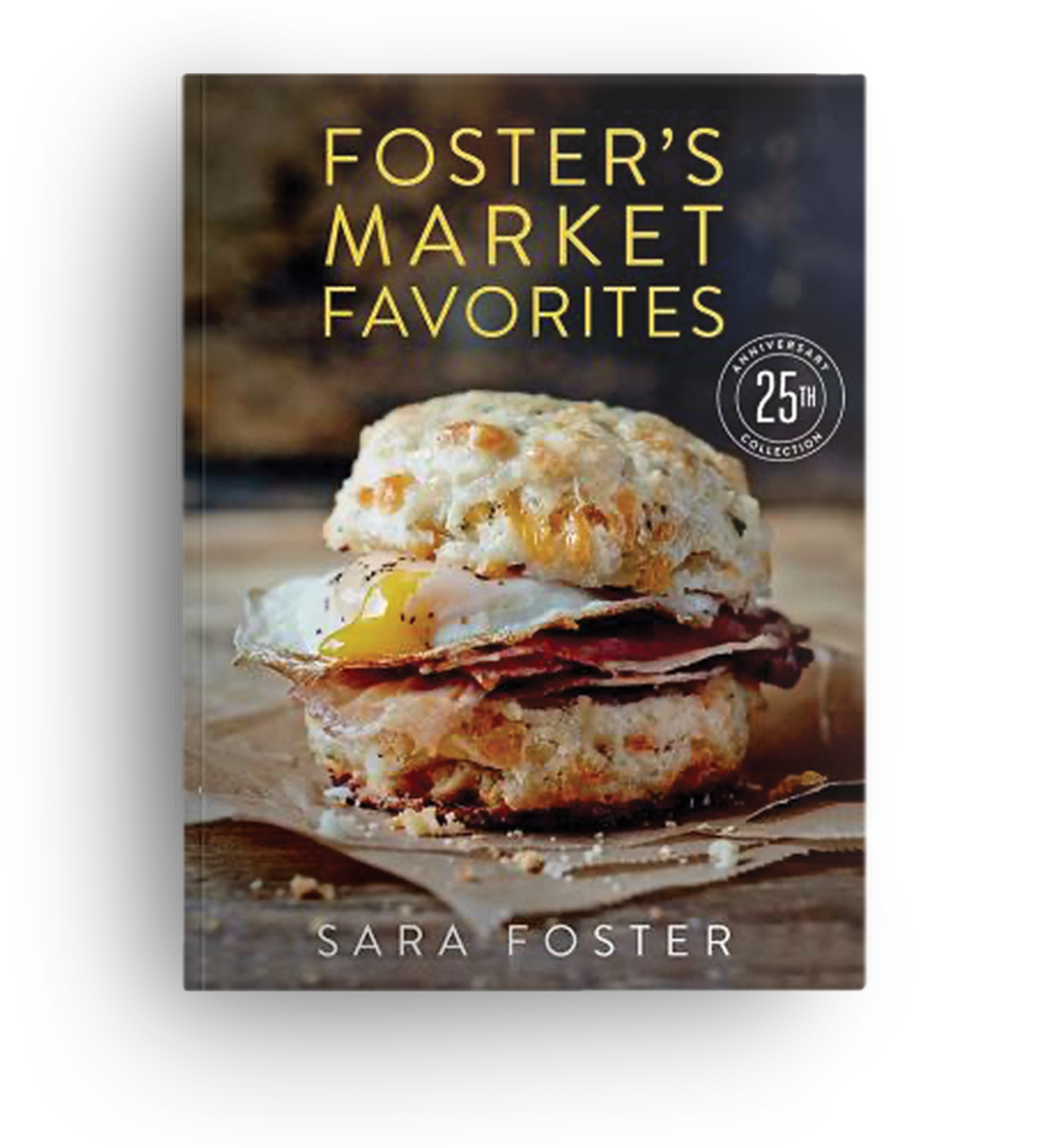 Book titled 'Foster's Market Favorites' showing a sandwich with a biscuit, fried egg, and sliced meat on a wooden surface.