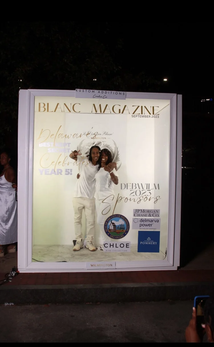 Three guests celebrating inside the Deluxe Magazine Booth