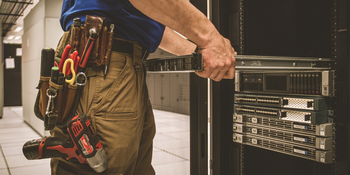 Technician installing equipment in a server cabinet as part of scalable data center infrastructure.