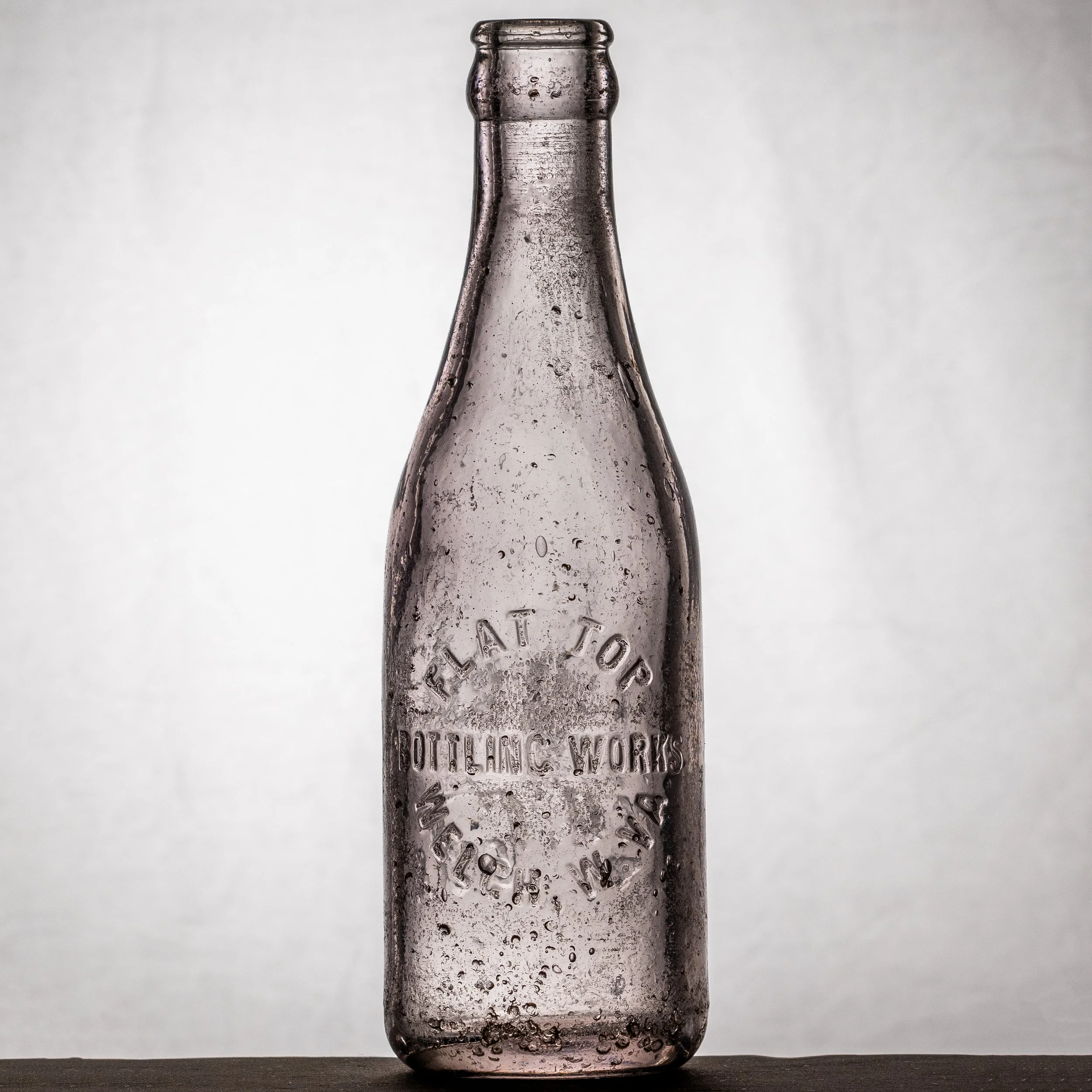 Flat Top Bottling Works, Welch soda bottle. Straight sided Coca-Cola, colorless glass, BIMAL mold, crude. Front.