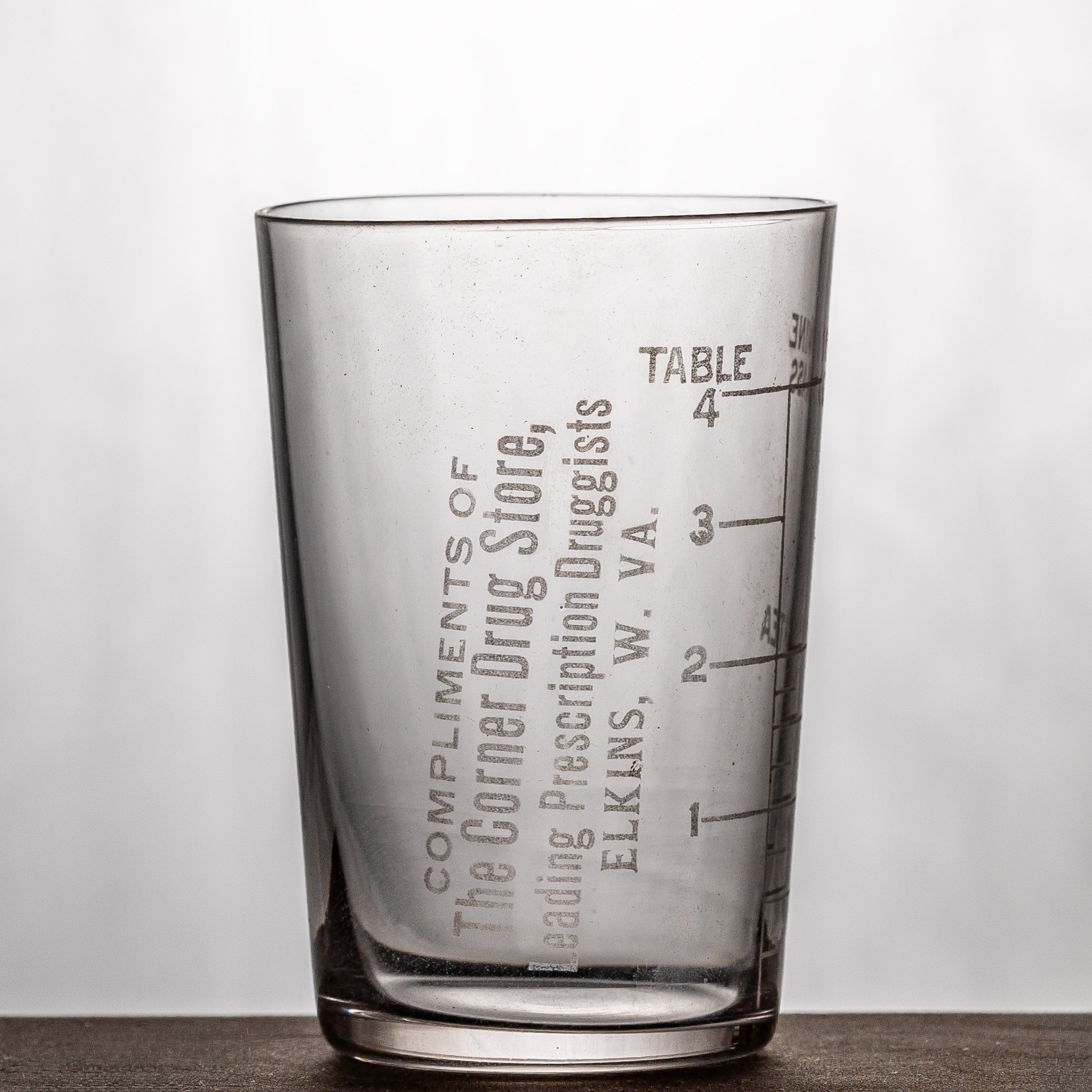 The Corner Drug Store, Elkins dose glass. Acid-etched text, 4-tablespoons capacity.