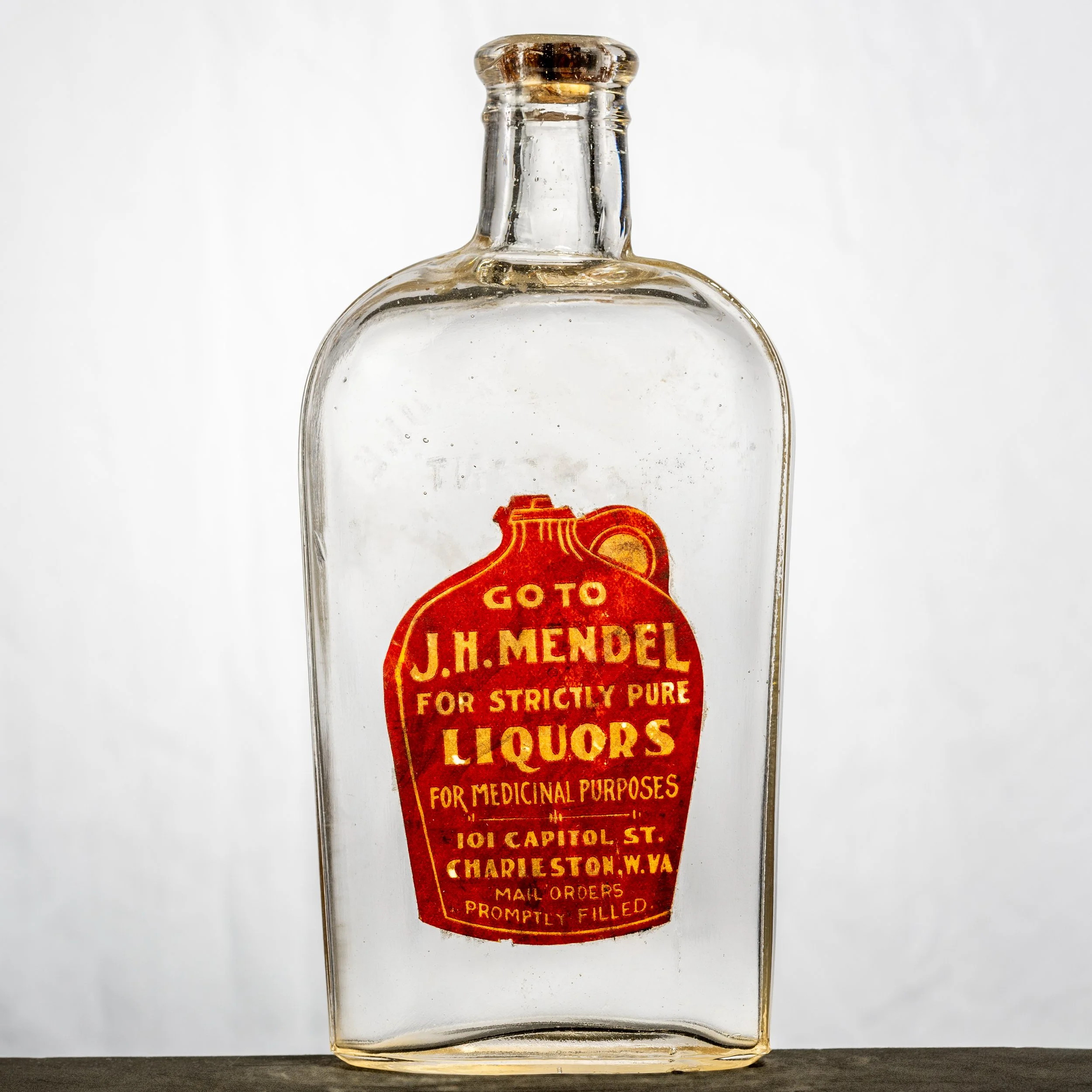 J.H. Mendel, Charleston labeled whiskey bottle. Label is shaped like a jug, noting their liquor is "for medicinal purposes," which was a legal loophole.