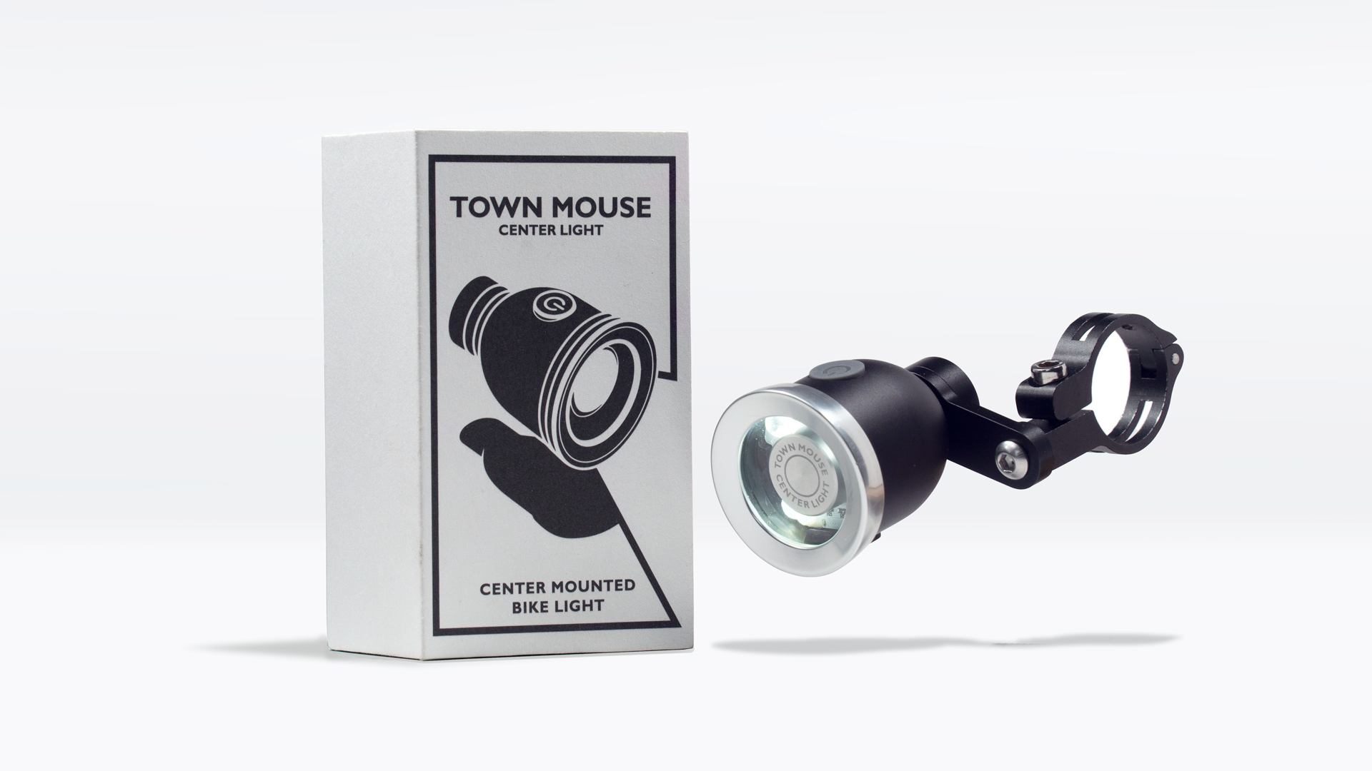 Bike light beside matching box labeled 'Town Mouse Center Light,' showing design and mounting hardware.