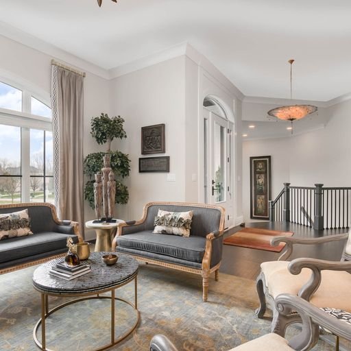 Living room with gray sofas, a marble coffee table, curtains, and decorative wall art.