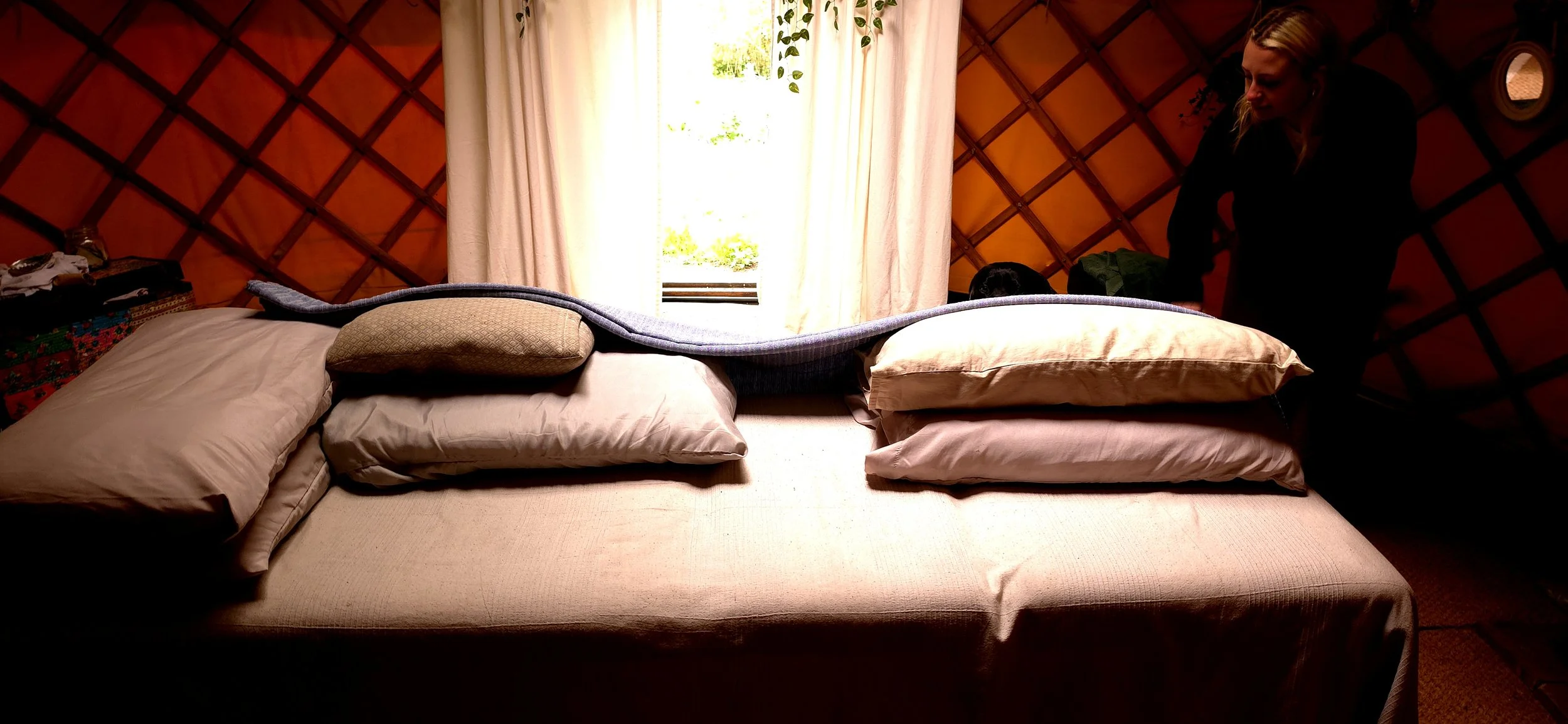 A massage bed with pillows and blankets, set up with a prenatal or pregnancy massage, at Root to Heal, Beccles, Henham, Suffolk