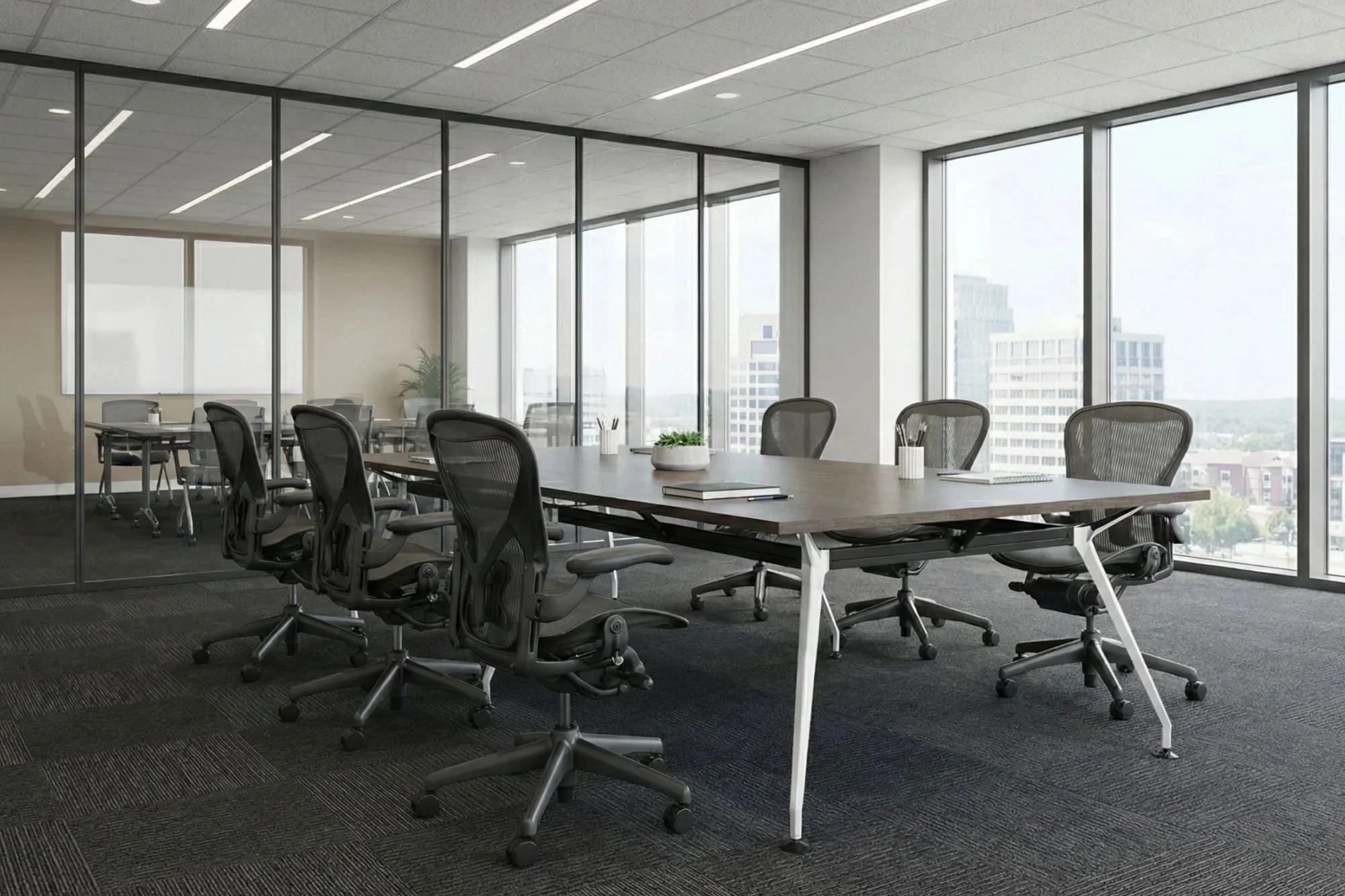Modern office conference room with a large wooden table surrounded by black ergonomic chairs, large windows with a city skyline view, and a glass partition wall.