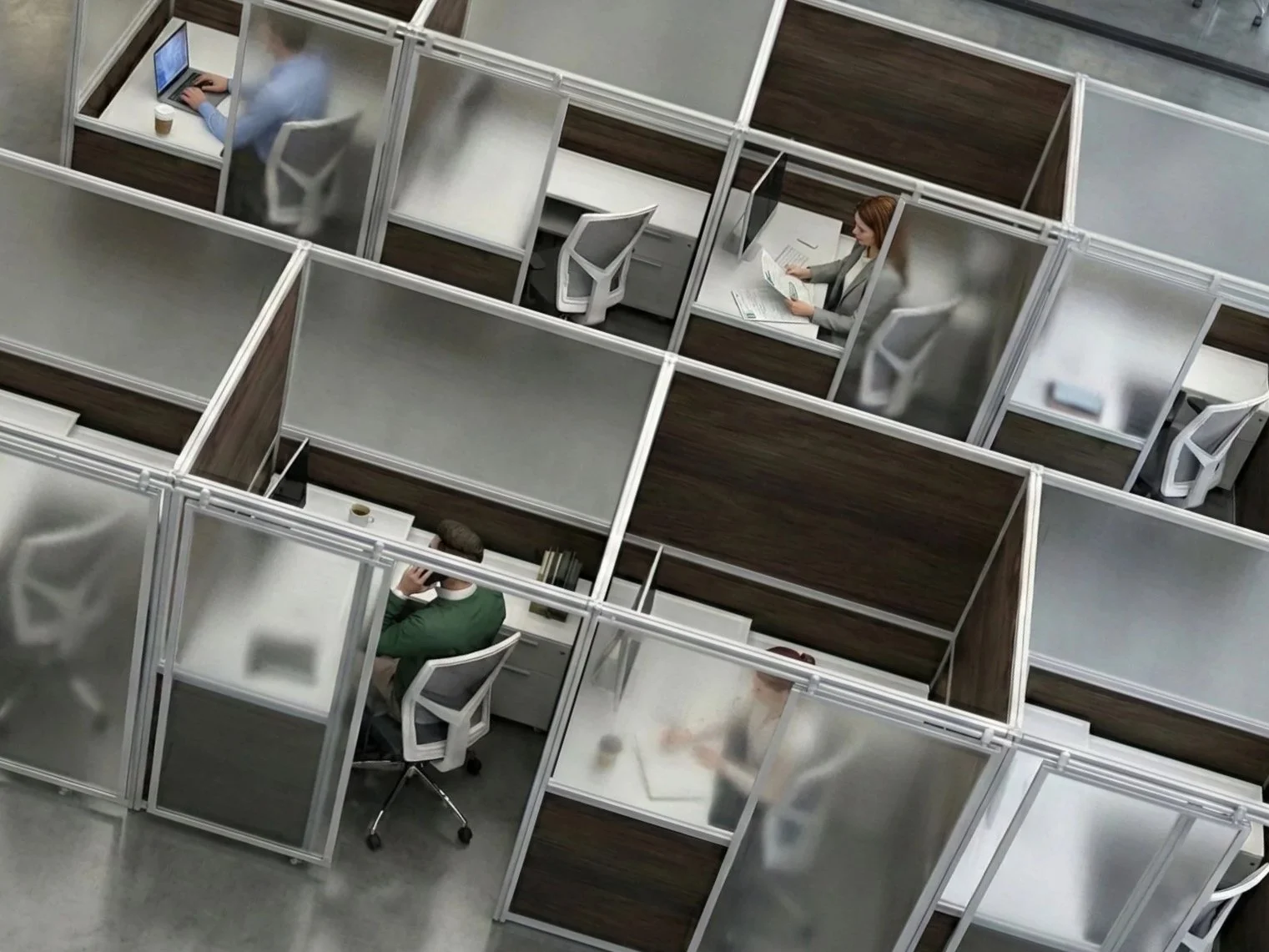 An aerial view of an office with multiple cubicles separated by frosted glass panels, each with an office chair and a desk.
